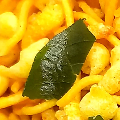 Close-up of a fried curry leaf in the mixture
